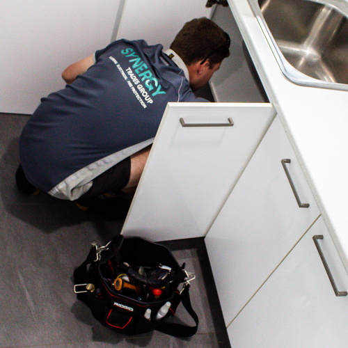 Synergy Trades Group - Plumbers in Action - Our professional plumber is fixing the kitchen sink